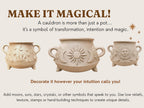 three decorative cauldrons with various symbols and designs, including stars, moons, and suns, along with a text overlay that encourages viewers to make their own magical cauldrons by decorating them according to their individual beliefs and intentions.