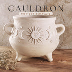 a white ceramic cauldron with a sun and moon design, placed on a wooden surface.