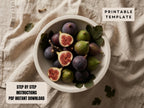 A bowl filled with sliced figs and leaves, placed on a beige cloth.