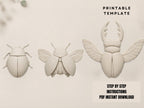three white sculptures of insects, including a large beetle, a smaller fly, and a ladybug, arranged in a row.