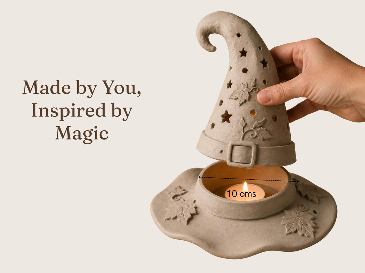 A hand is holding a small candle holder in the shape of a wizard's hat, with a lit candle inside.