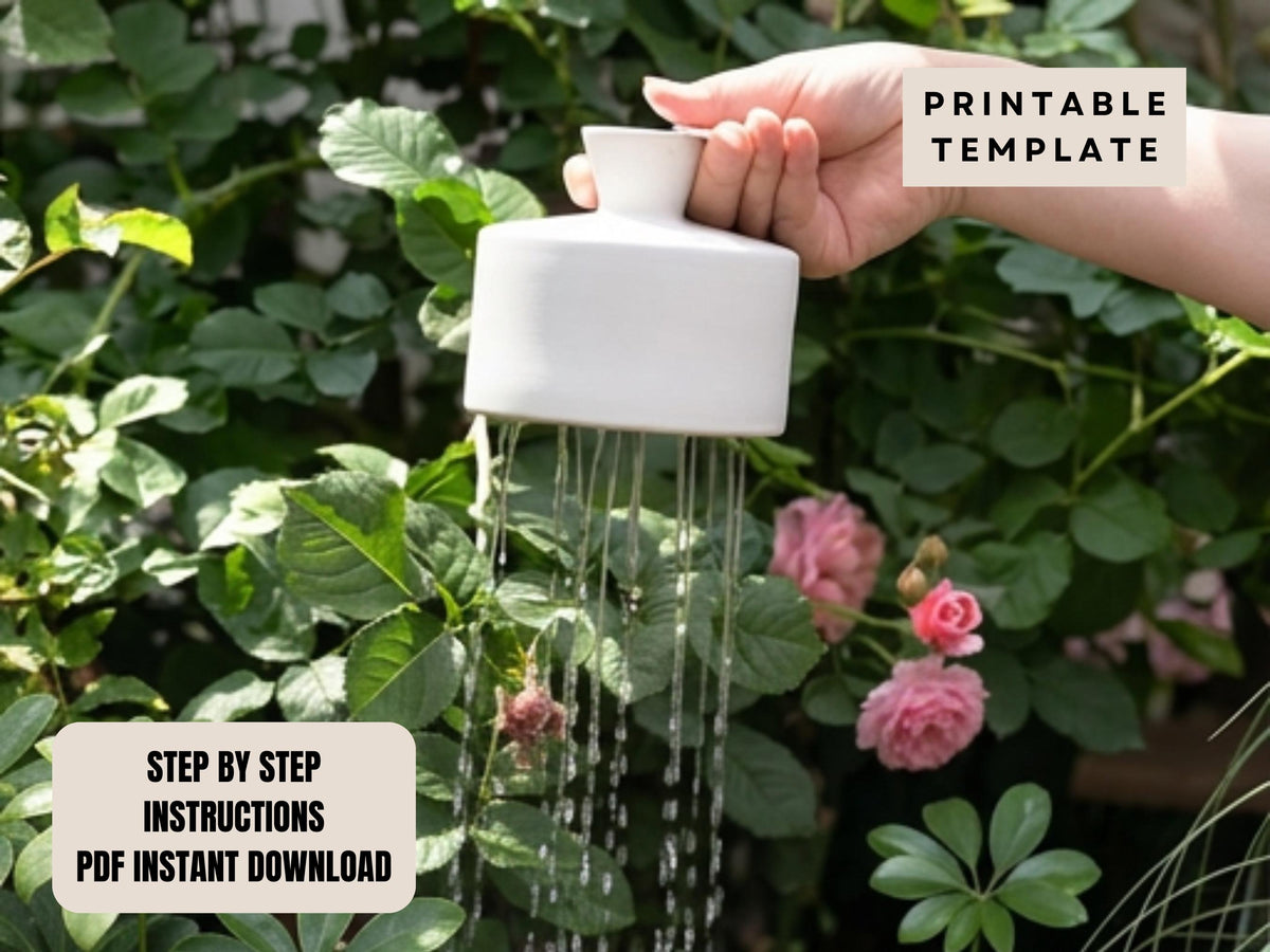 A hand is holding a white watering can with water dripping from it, surrounded by lush green foliage and pink flowers.