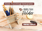a set of paintbrushes in a wooden holder, along with a brush and a piece of paper, suggesting a painting or art-related activity.