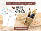 a slab building template for a brush holder, along with a set of paintbrushes and a wooden surface.