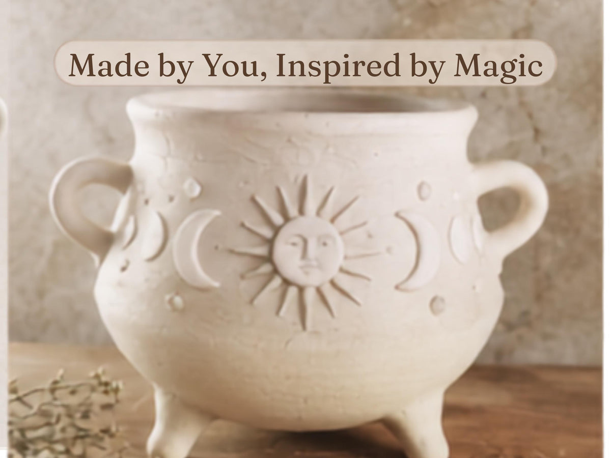 A white ceramic pot with a sun and moon design, sitting on a wooden surface.