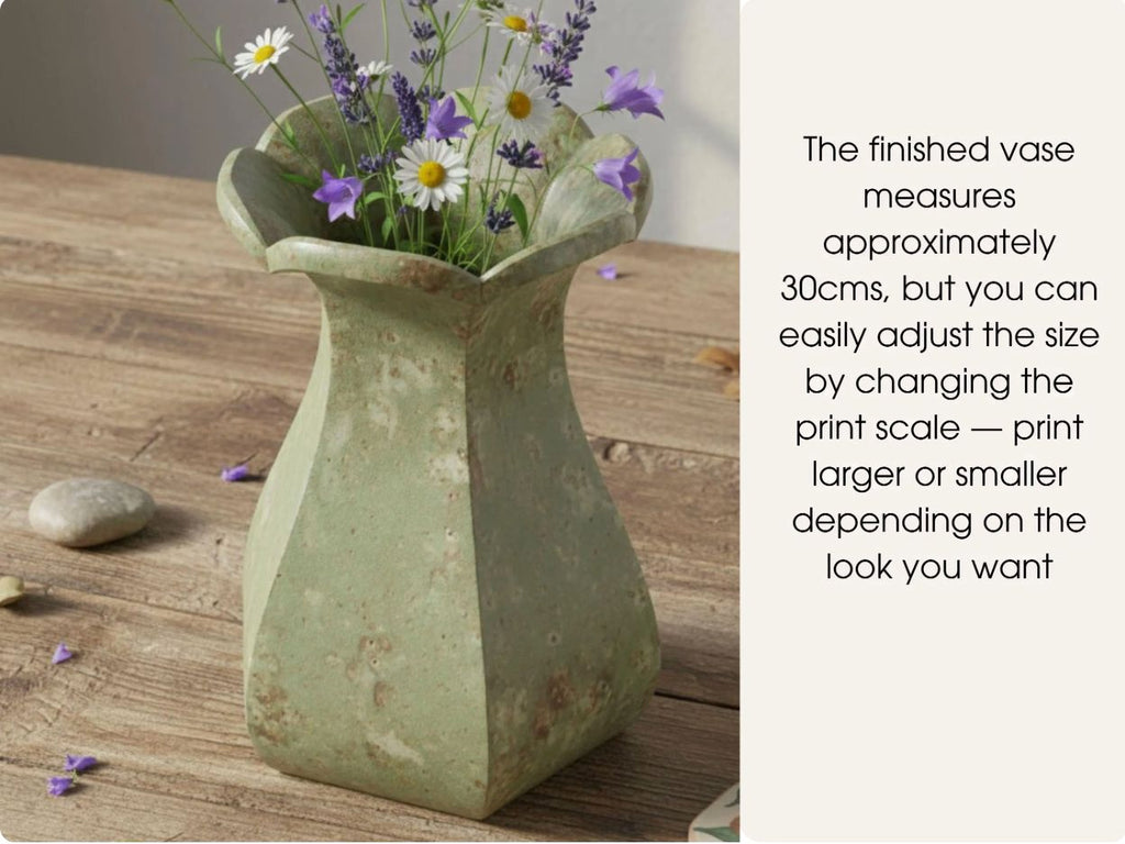 a green vase filled with purple and white flowers, placed on a wooden surface.