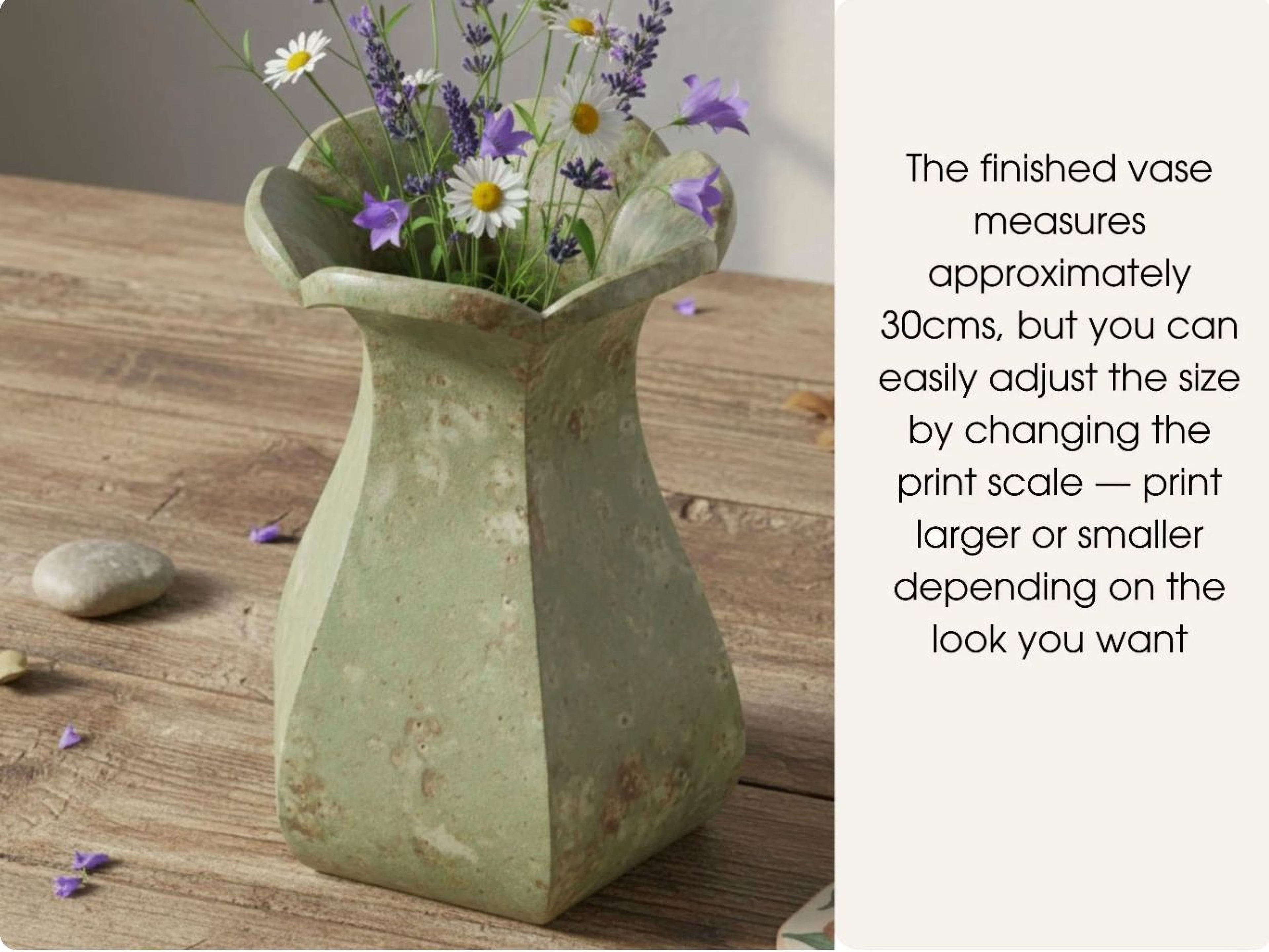 a green vase filled with purple and white flowers, placed on a wooden surface.