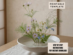 a white bowl filled with a variety of colorful flowers, including purple and blue blooms, placed on a wooden surface.