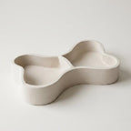 A white ceramic bowl with a unique, curved shape.