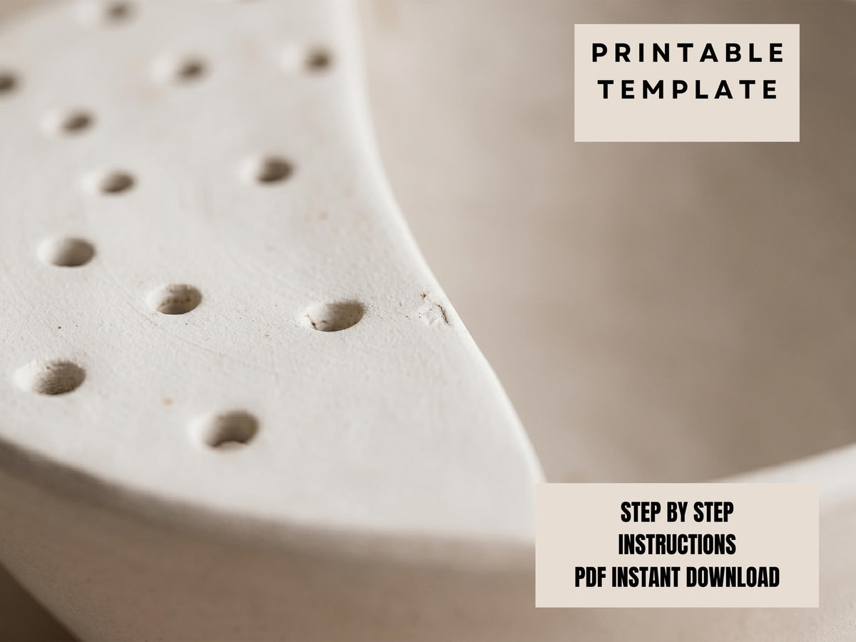 The image is a close-up of a white ceramic object with numerous small holes or perforations on its surface.