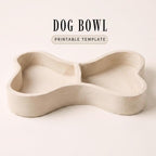 A simple, minimalist dog bowl made of a light-colored material, such as ceramic or plastic, with a curved shape and two compartments.