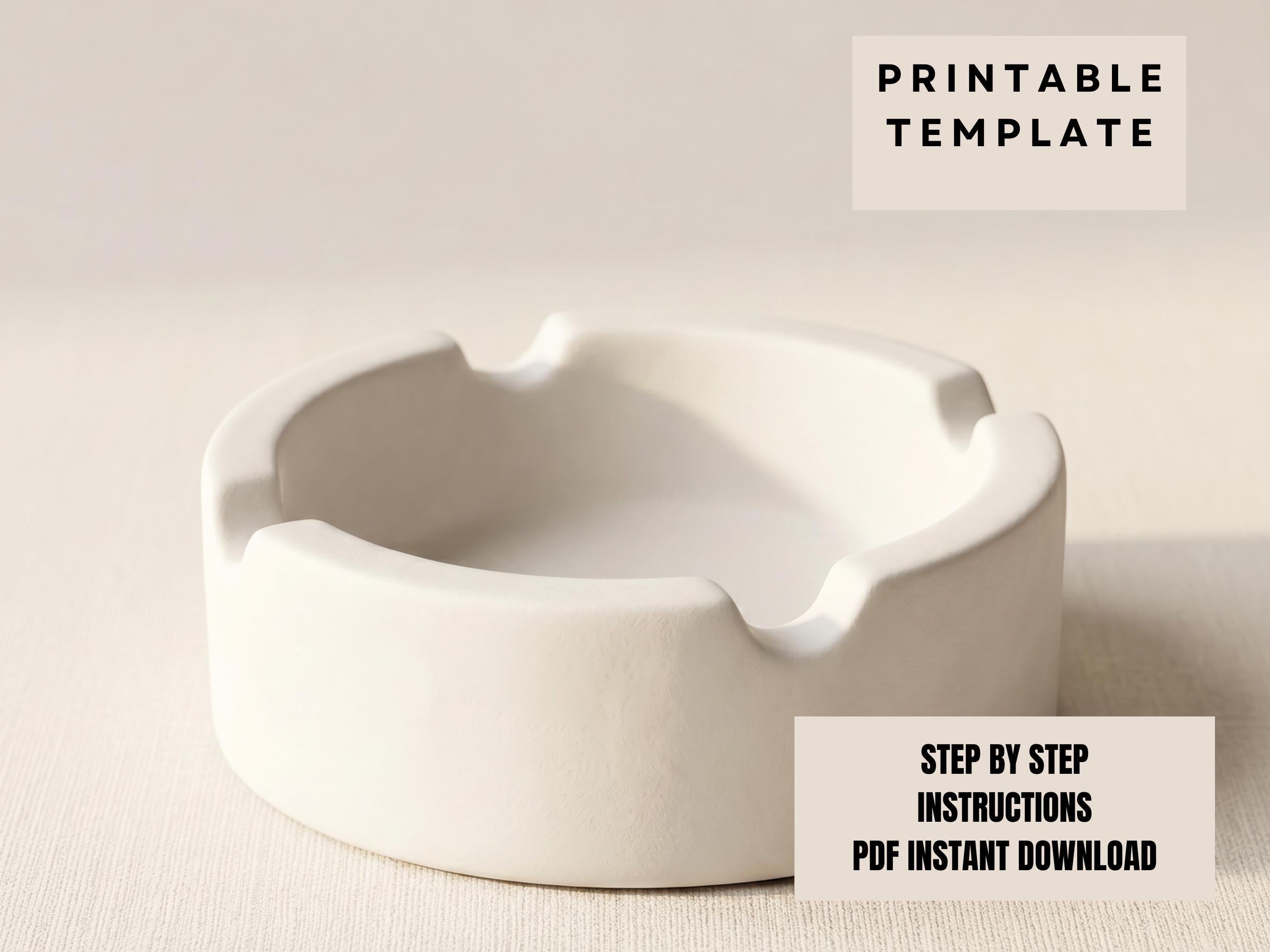 A white ceramic ashtray sits on a plain background.