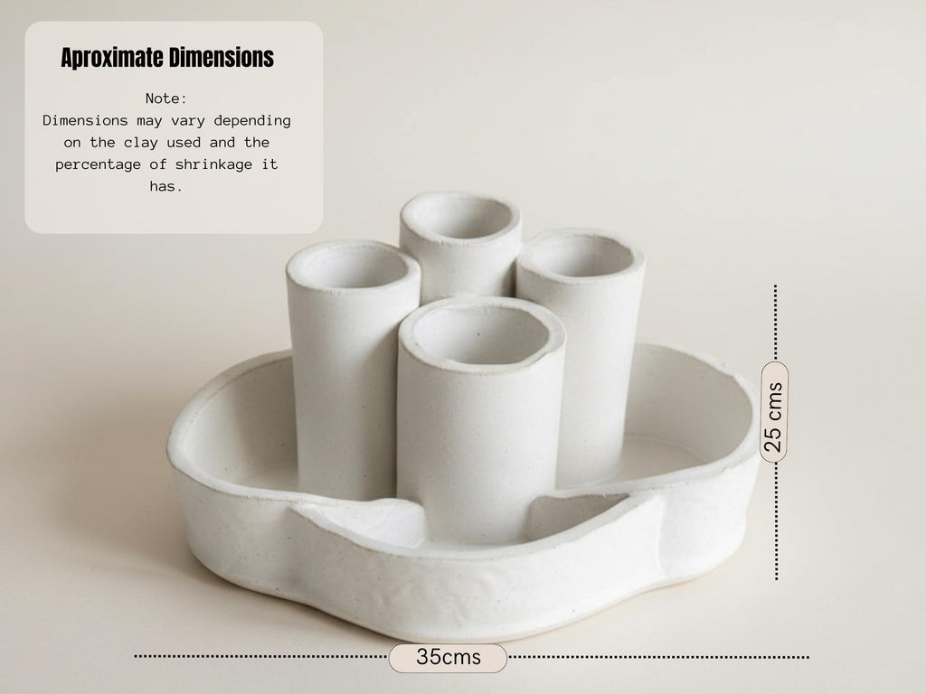 a white ceramic object with a curved shape, possibly a vase or container, placed on a white surface.