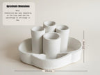 a white ceramic object with a curved shape, possibly a vase or container, placed on a white surface.