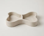 A simple, white ceramic bowl or dish with a curved, organic shape.
