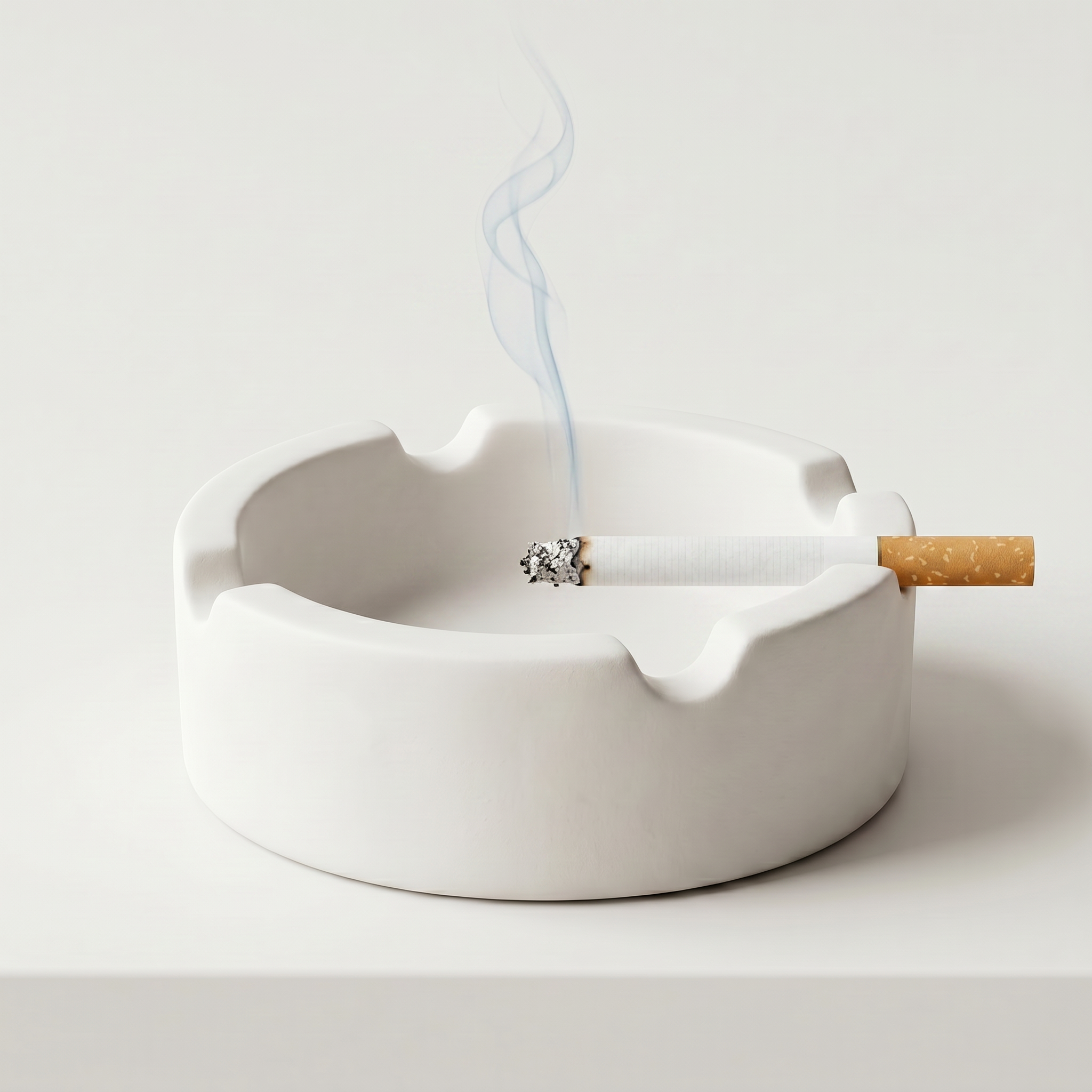 A white ceramic ashtray containing a lit cigarette, with smoke rising from it.