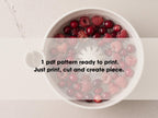 A bowl filled with raspberries and cranberries, with water being poured into it.