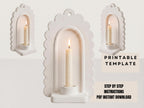a white candle holder with a lit candle inside, set against a plain white background.