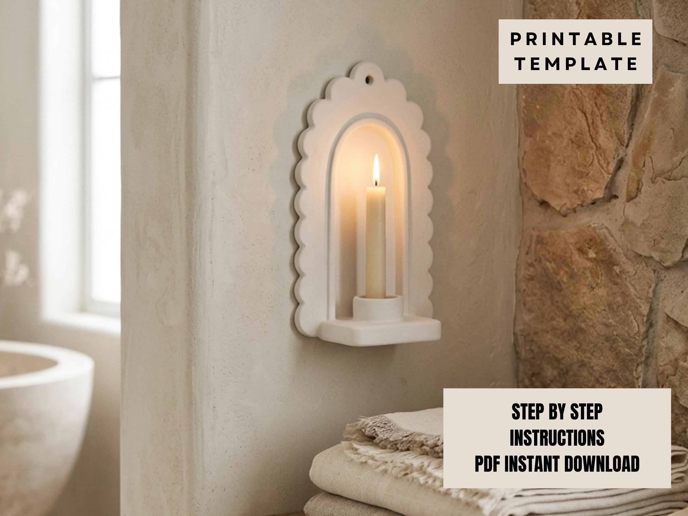a white scalloped-edge wall-mounted candle holder with a lit candle inside, placed on a shelf next to a stack of towels.