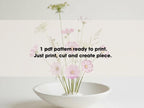 a white bowl containing a bouquet of pink and white flowers, with a text overlay that reads "1 pdf pattern ready to print. Just print, cut and create piece."